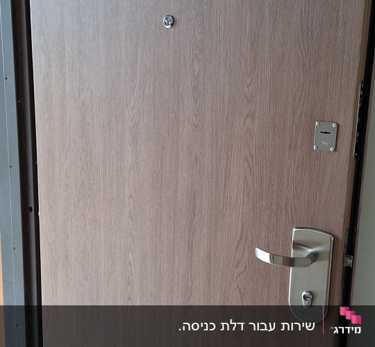 דלת עץ עם ידית מתכת ומנעול